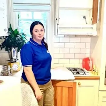 A House Removalists Melbourne crew member in a blue polo standing in a Melbourne kitchen mid-pack