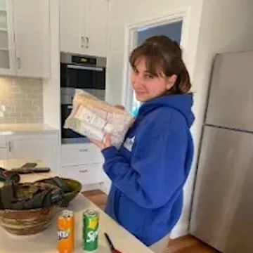 A crew member wrapping crockery at a kitchen bench before packing it